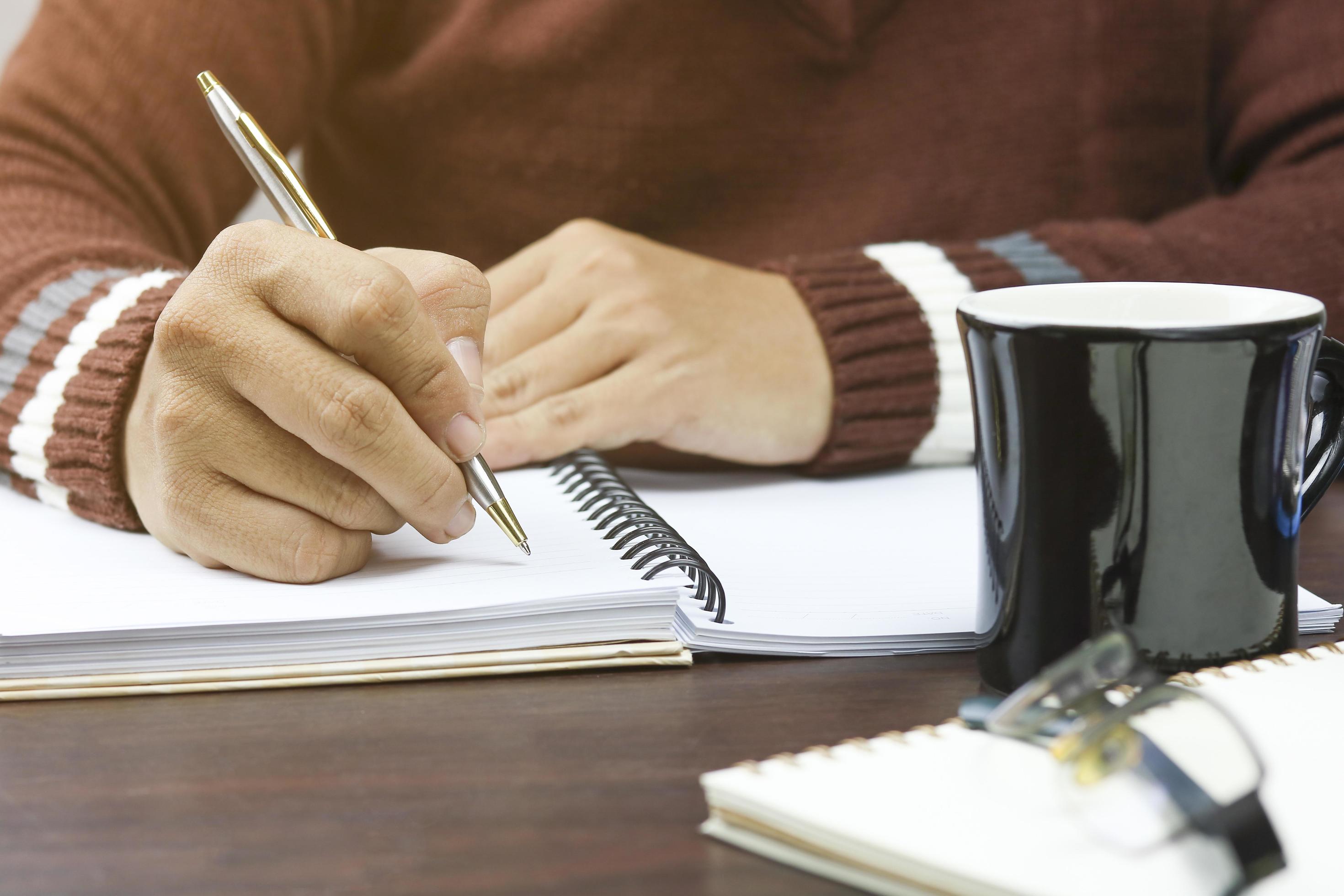 1259853-persona-che-scrive-nel-planner-gratuito-foto